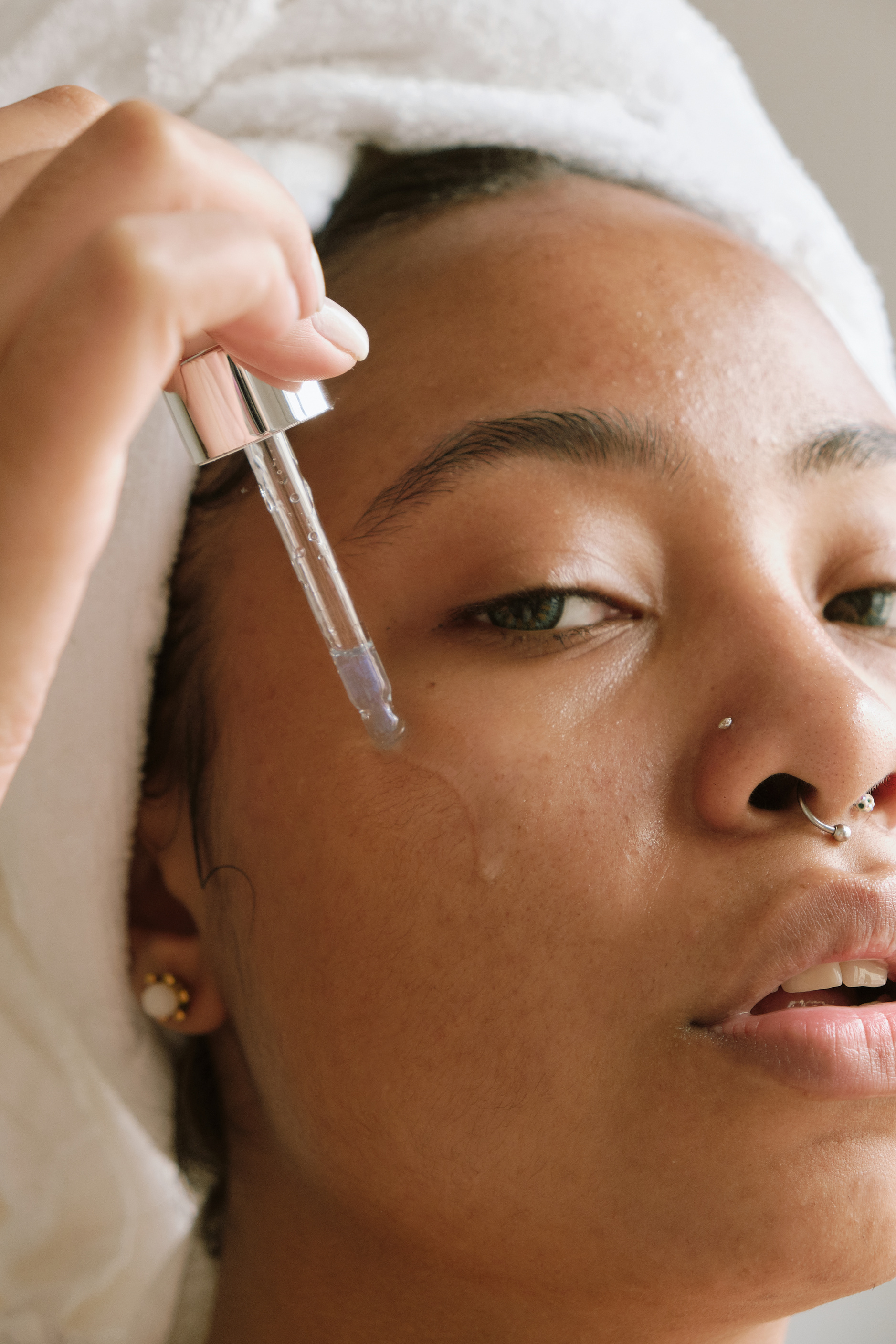 Woman Applying Serum on Face with a Dropper